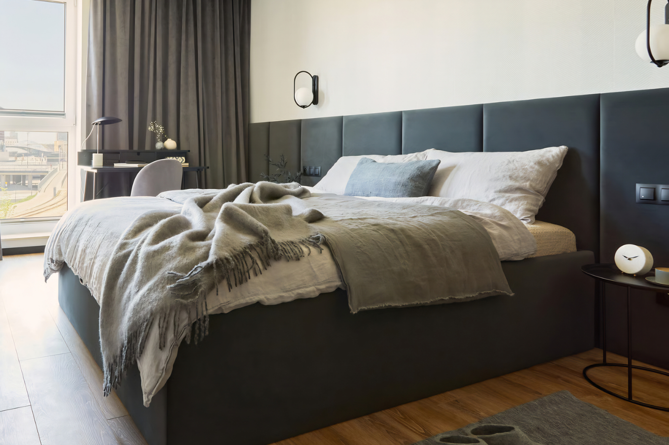 Contemporary furnished apartment bedroom with a comfortable bed and natural light